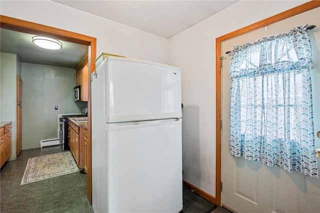 kitchen with a baseboard radiator, appliances with stainless steel finishes, brown cabinetry, and baseboards