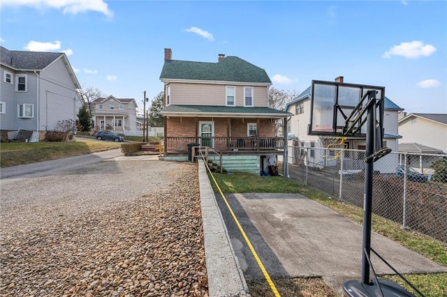 view of front of property with roof with shingles, a chimney, a porch, fence, and a residential view