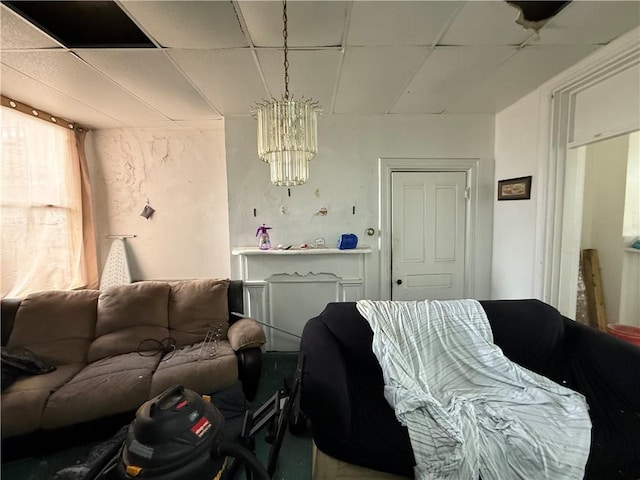 living area with a chandelier and a drop ceiling