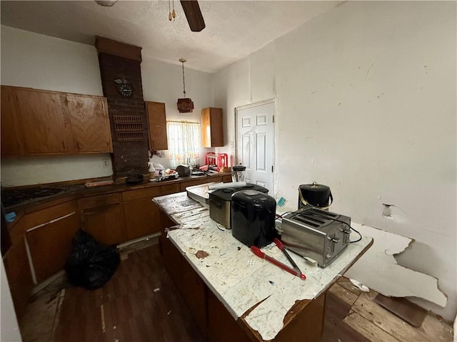 kitchen featuring ceiling fan, vaulted ceiling, brown cabinets, and dark wood-style flooring