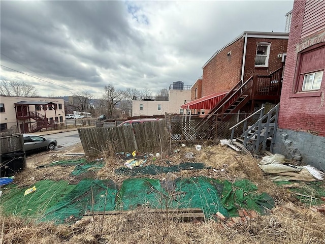 view of yard featuring fence and stairway