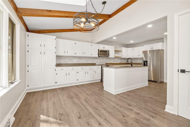 kitchen featuring lofted ceiling with beams, stainless steel appliances, visible vents, white cabinetry, and backsplash