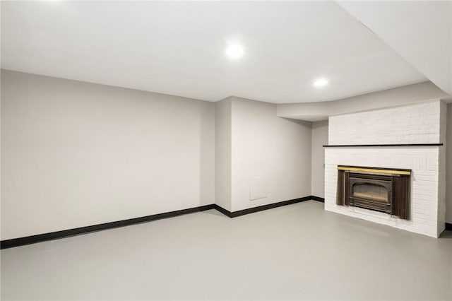 unfurnished living room with finished concrete floors, recessed lighting, a fireplace, and baseboards