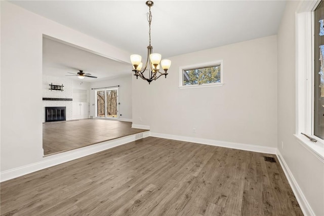 interior space featuring visible vents, a fireplace, baseboards, and wood finished floors