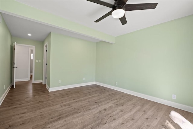 empty room featuring ceiling fan, baseboards, and wood finished floors