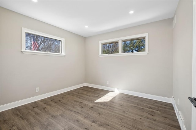 empty room featuring baseboards, dark wood-style flooring, and recessed lighting