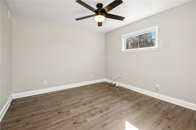 empty room with ceiling fan, visible vents, baseboards, and wood finished floors