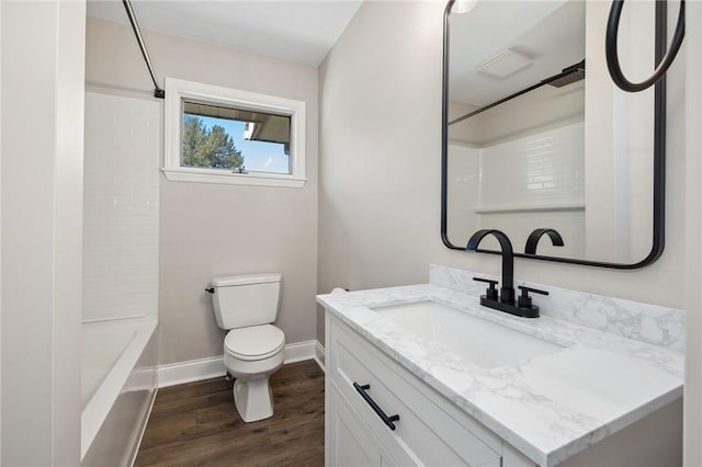 bathroom featuring toilet, washtub / shower combination, vanity, wood finished floors, and baseboards