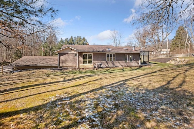 back of property with fence and a lawn