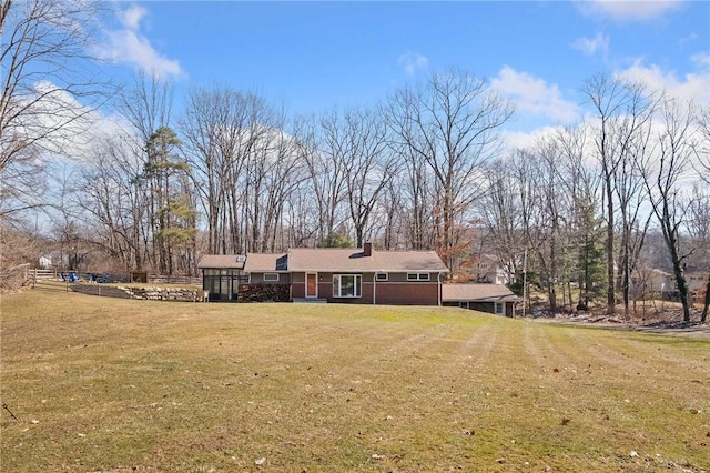 view of front facade featuring a chimney and a front lawn