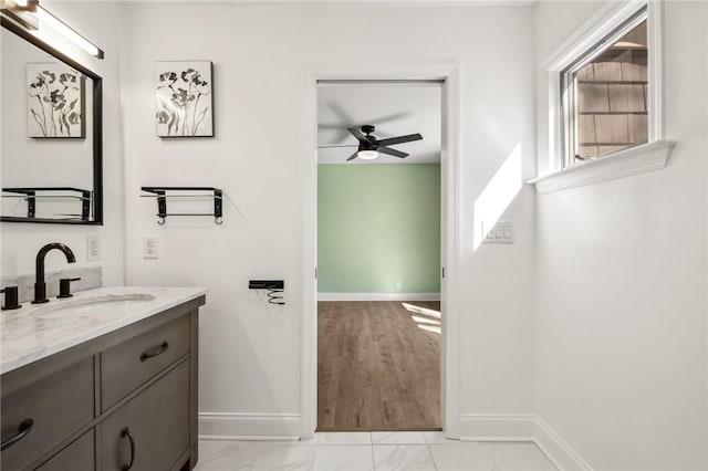 bathroom with ceiling fan, baseboards, and vanity