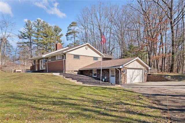 view of side of property with a garage, driveway, a chimney, and a lawn