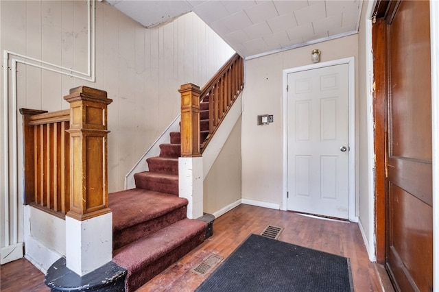 entrance foyer featuring stairs, wood finished floors, visible vents, and baseboards