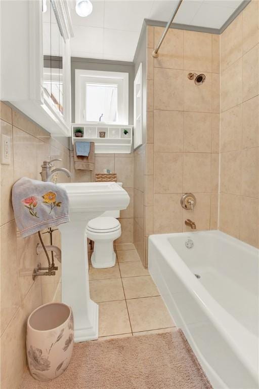 bathroom featuring toilet, bathing tub / shower combination, tile patterned flooring, and tile walls