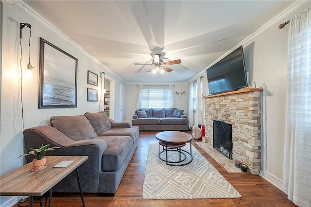 living room with ceiling fan, ornamental molding, wood finished floors, and a stone fireplace