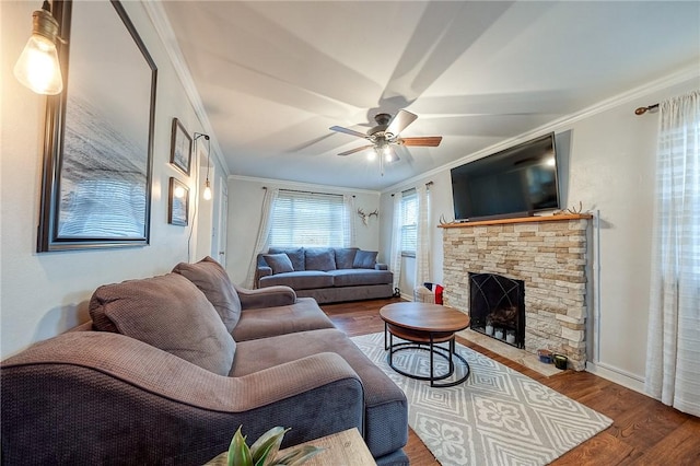 living area featuring a fireplace, ornamental molding, and wood finished floors