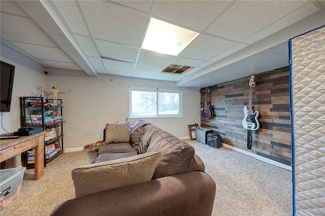 living room featuring wood walls, baseboards, and carpet flooring