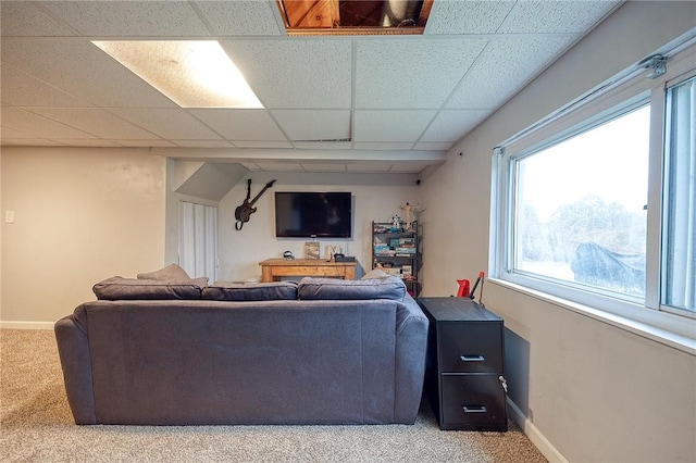 living area with carpet, a paneled ceiling, and baseboards