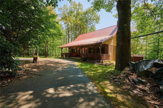 exterior space with covered porch, metal roof, and driveway