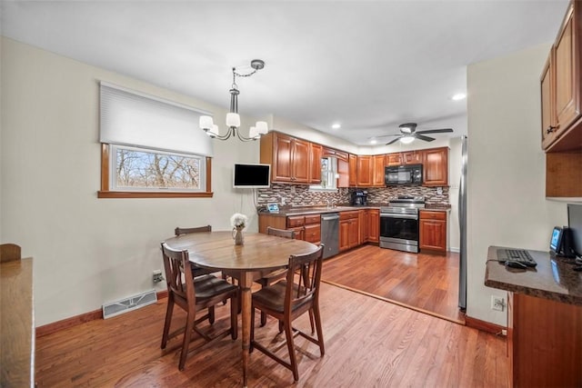 dining room featuring light wood-style floors, baseboards, visible vents, and a chandelier