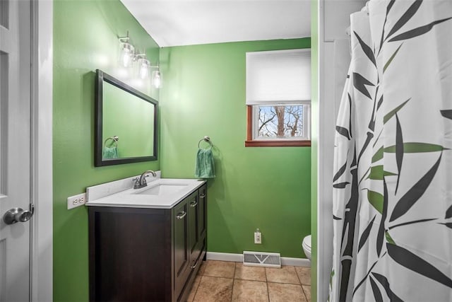 bathroom featuring visible vents, baseboards, toilet, tile patterned flooring, and vanity