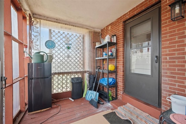 exterior space with brick wall and hardwood / wood-style flooring