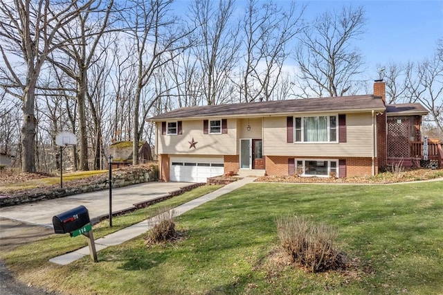 split foyer home with driveway, brick siding, a chimney, an attached garage, and a front yard