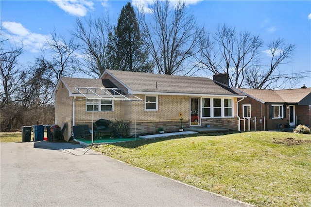 ranch-style house with a front lawn, a chimney, and brick siding