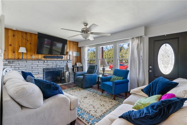 living room with ceiling fan, a fireplace, and wood finished floors