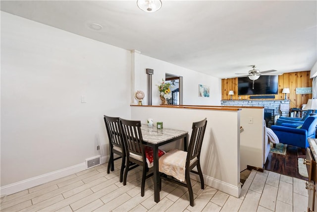 dining space featuring a ceiling fan, wood finish floors, visible vents, and baseboards