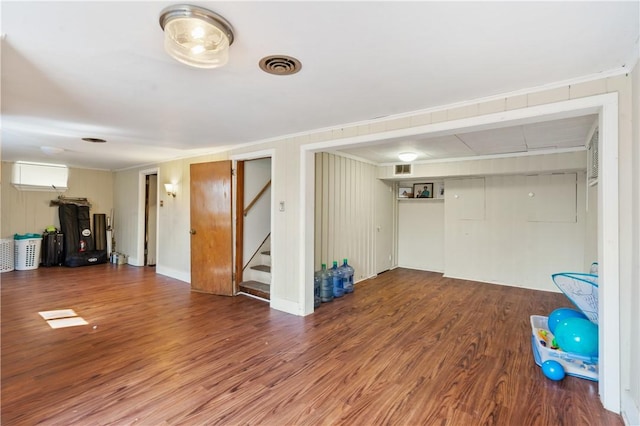 interior space featuring stairway, crown molding, visible vents, and wood finished floors