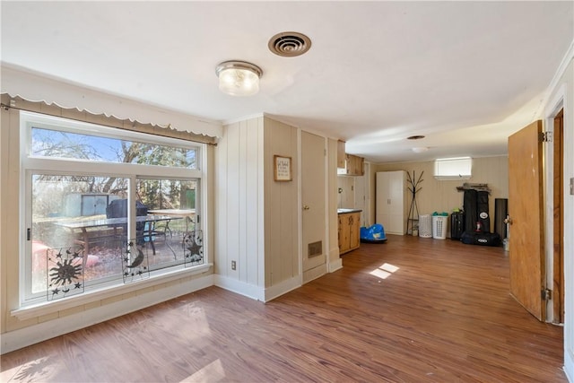 interior space with baseboards, visible vents, and wood finished floors