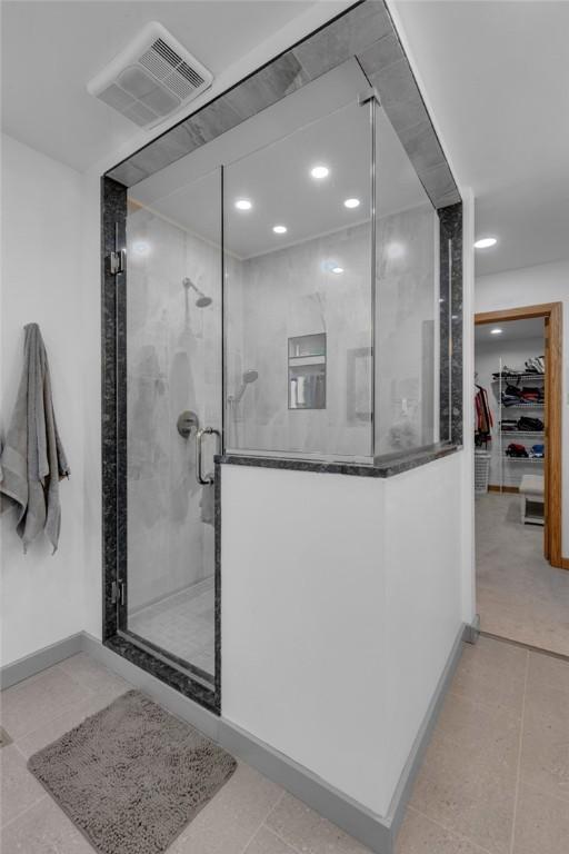 bathroom featuring visible vents, tile patterned floors, a walk in closet, a shower stall, and recessed lighting