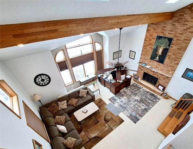 living room with a fireplace with raised hearth, high vaulted ceiling, ceiling fan, and beam ceiling