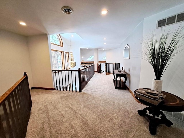 hallway with visible vents, carpet flooring, an upstairs landing, and recessed lighting