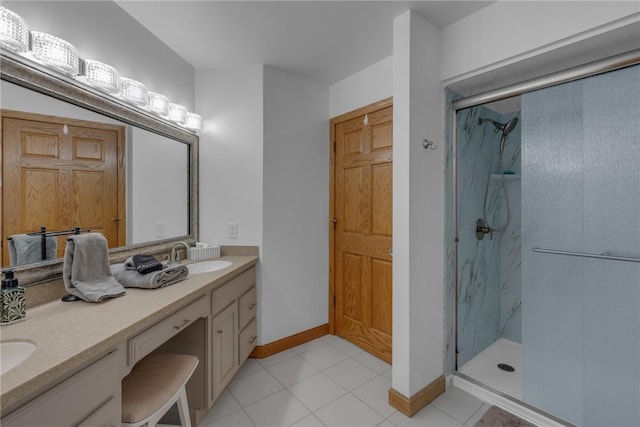 full bathroom featuring double vanity, a marble finish shower, baseboards, tile patterned floors, and a sink