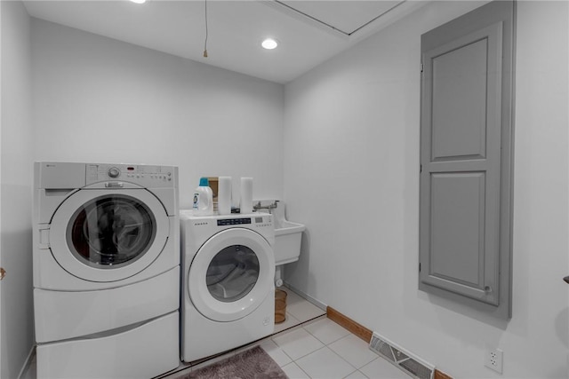 laundry room with laundry area, light tile patterned floors, visible vents, baseboards, and washing machine and dryer