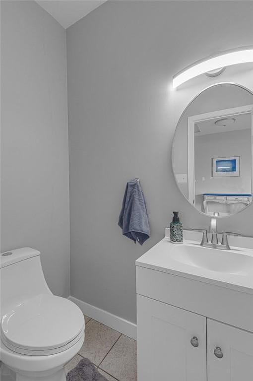 bathroom featuring baseboards, vanity, toilet, and tile patterned floors