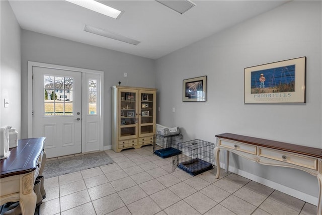 foyer entrance featuring light tile patterned flooring and baseboards