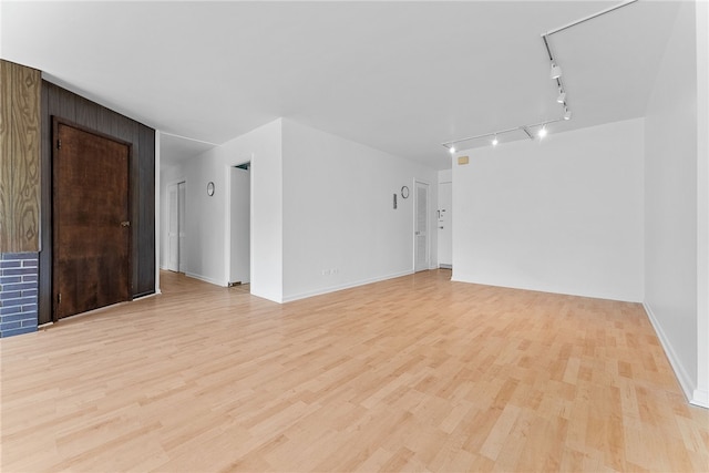 spare room featuring light wood-style floors and rail lighting