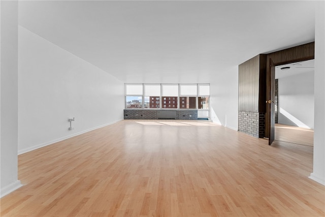 unfurnished living room featuring baseboards and wood finished floors