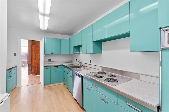 kitchen featuring light wood finished floors, stainless steel appliances, light countertops, blue cabinetry, and a sink