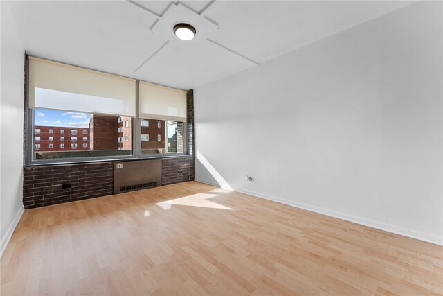 spare room with light wood-type flooring and baseboards