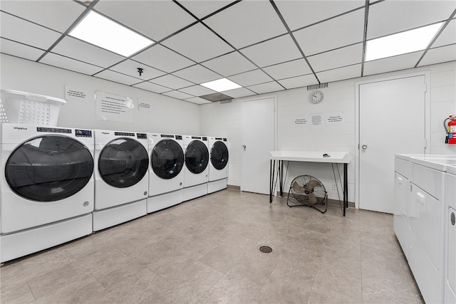 shared laundry area featuring concrete block wall and separate washer and dryer