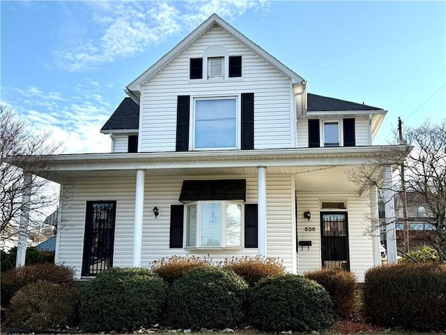 view of front of house with covered porch and a shingled roof