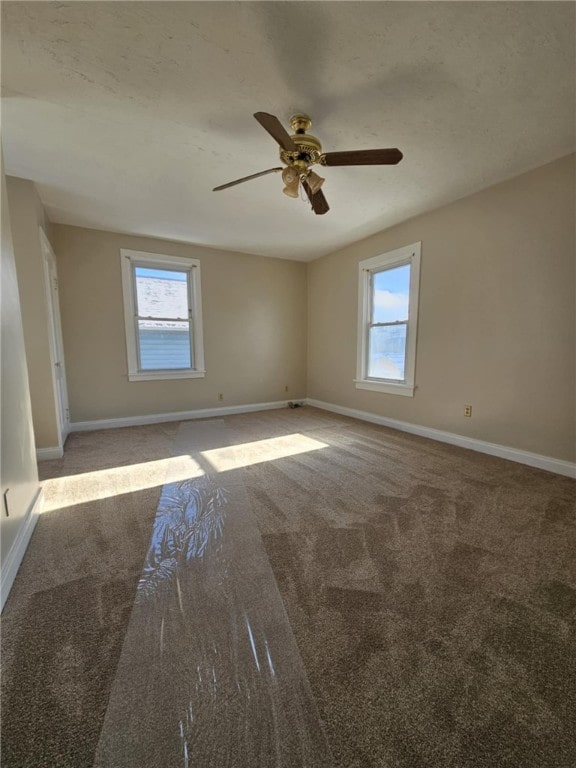 unfurnished room with carpet flooring, a healthy amount of sunlight, ceiling fan, and baseboards