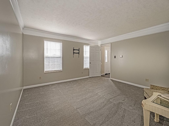 interior space with a textured ceiling, baseboards, dark colored carpet, and crown molding