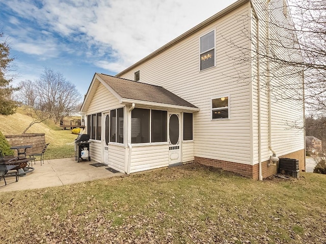 back of property with a yard, a patio area, a sunroom, and central air condition unit