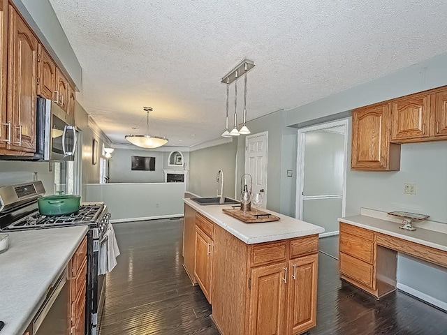 kitchen with dark wood finished floors, open floor plan, light countertops, stainless steel appliances, and a sink