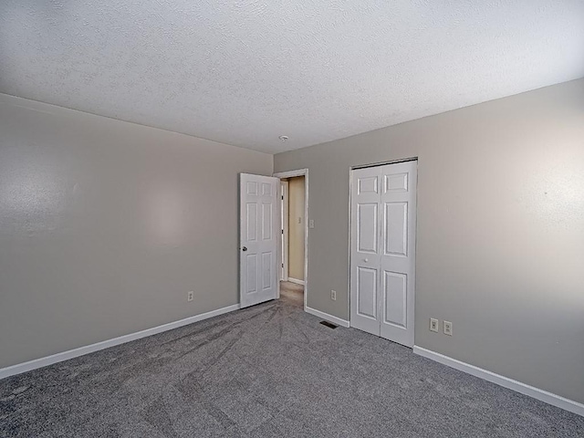 unfurnished bedroom with a closet, baseboards, a textured ceiling, and carpet floors